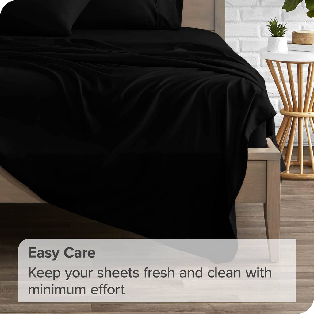 Black flat sheet fabric on a bed with gentle wrinkles and smooth drape