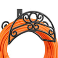 Black wall-mounted hose holder with ornate metal arch and hanging hose loop