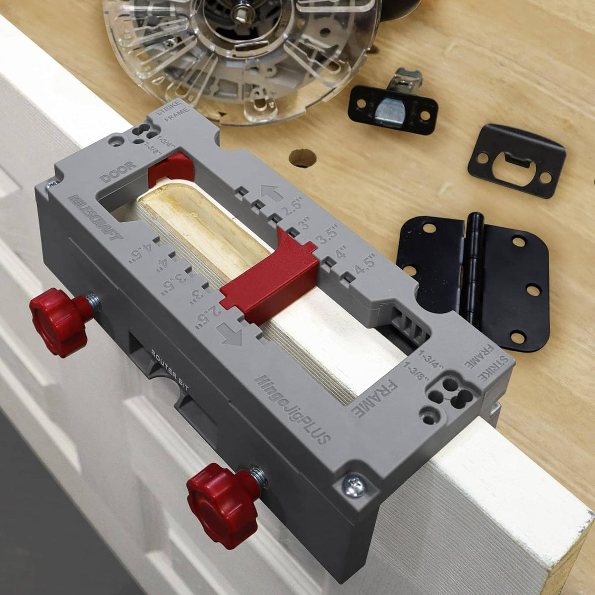 Door hinge mortising jig on a door frame edge with red clamping blocks and guide holes
