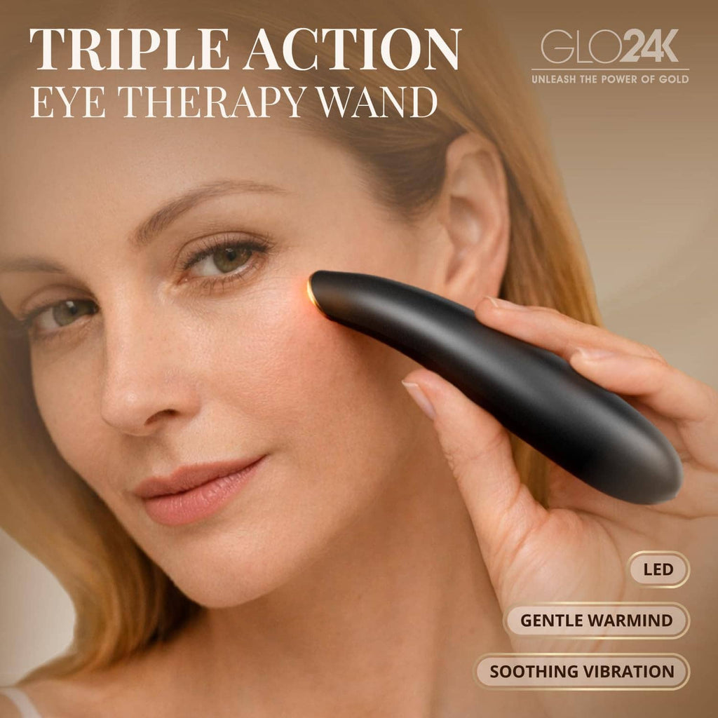 Black GLO24K heated eye wand touching under-eye area on a person’s face