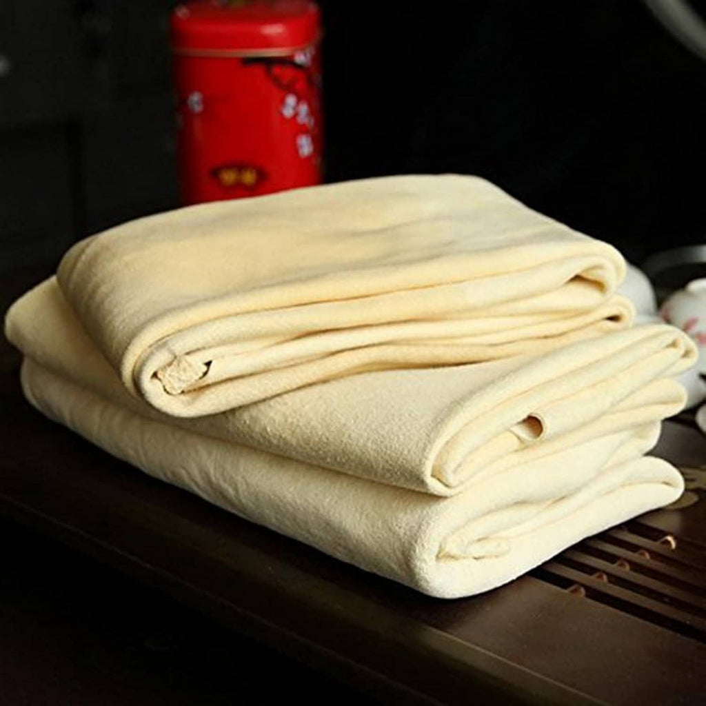 Folded off-white chamois leather cleaning cloth stacked, with curved roll edge