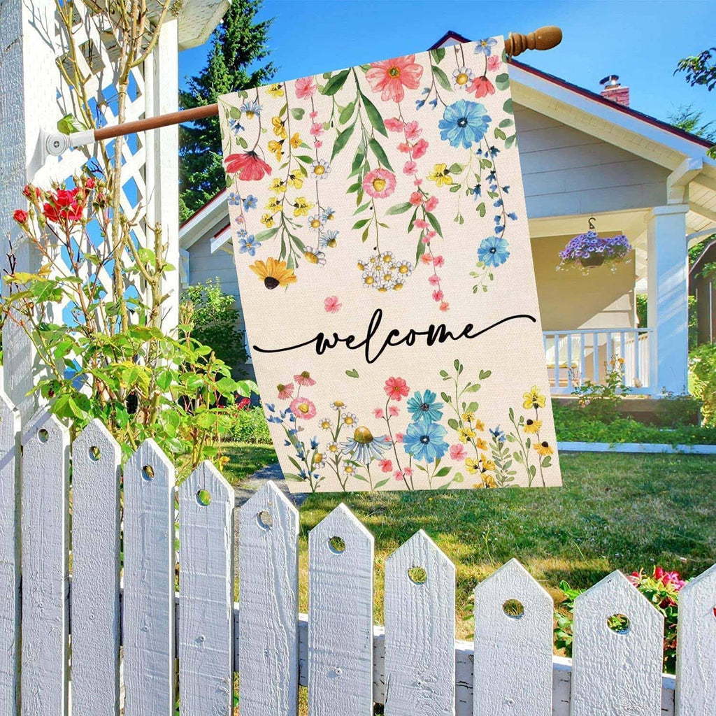Floral welcome yard flag on a wooden pole with multicolor blossoms and “welcome” script