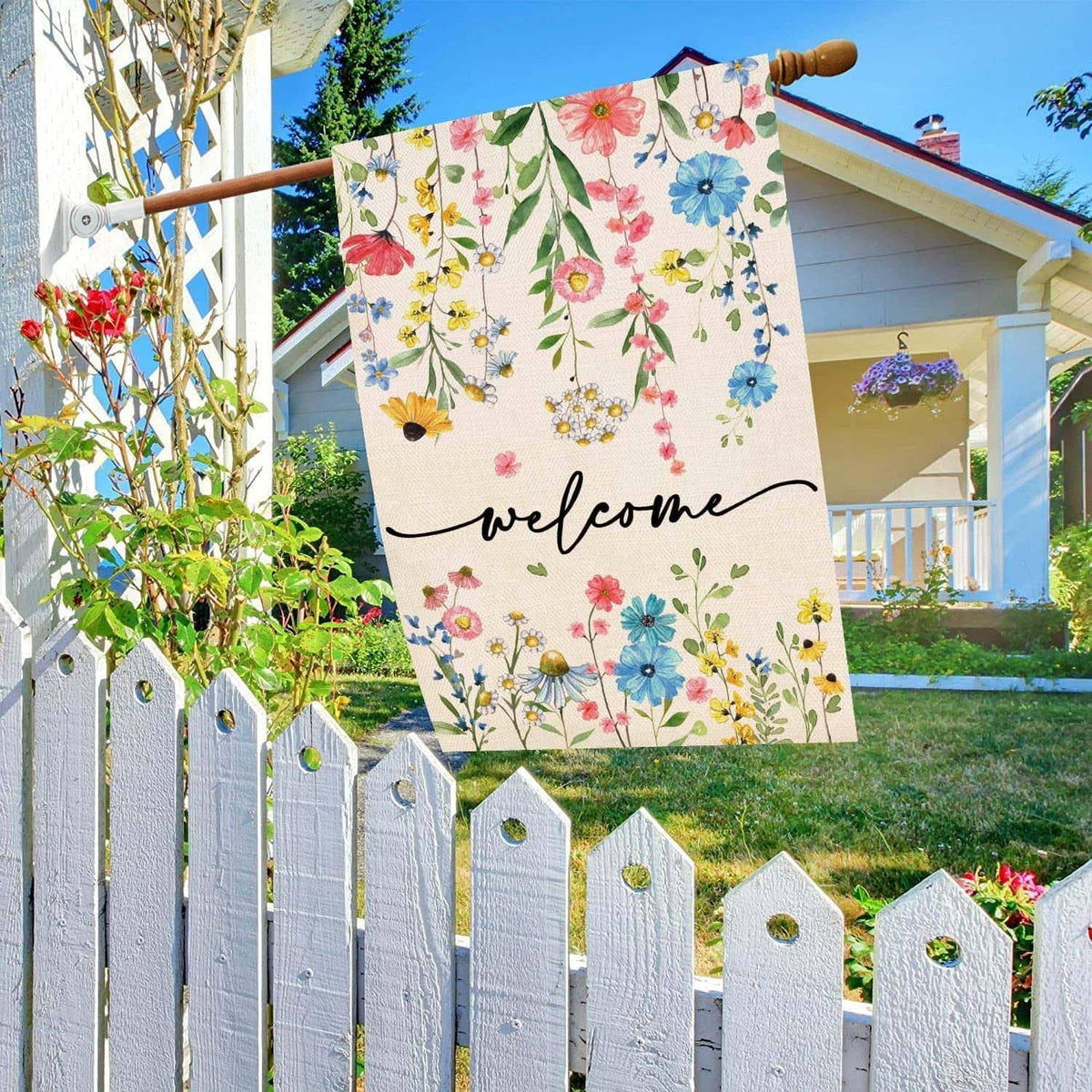Floral welcome yard flag on a wooden pole with multicolor blossoms and “welcome” script
