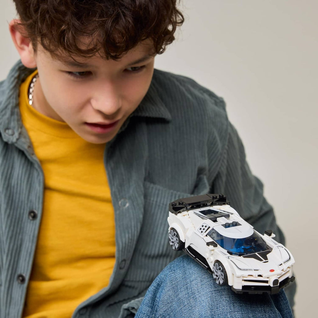 White LEGO toy sports car in hands, front-left view with blue windshield details