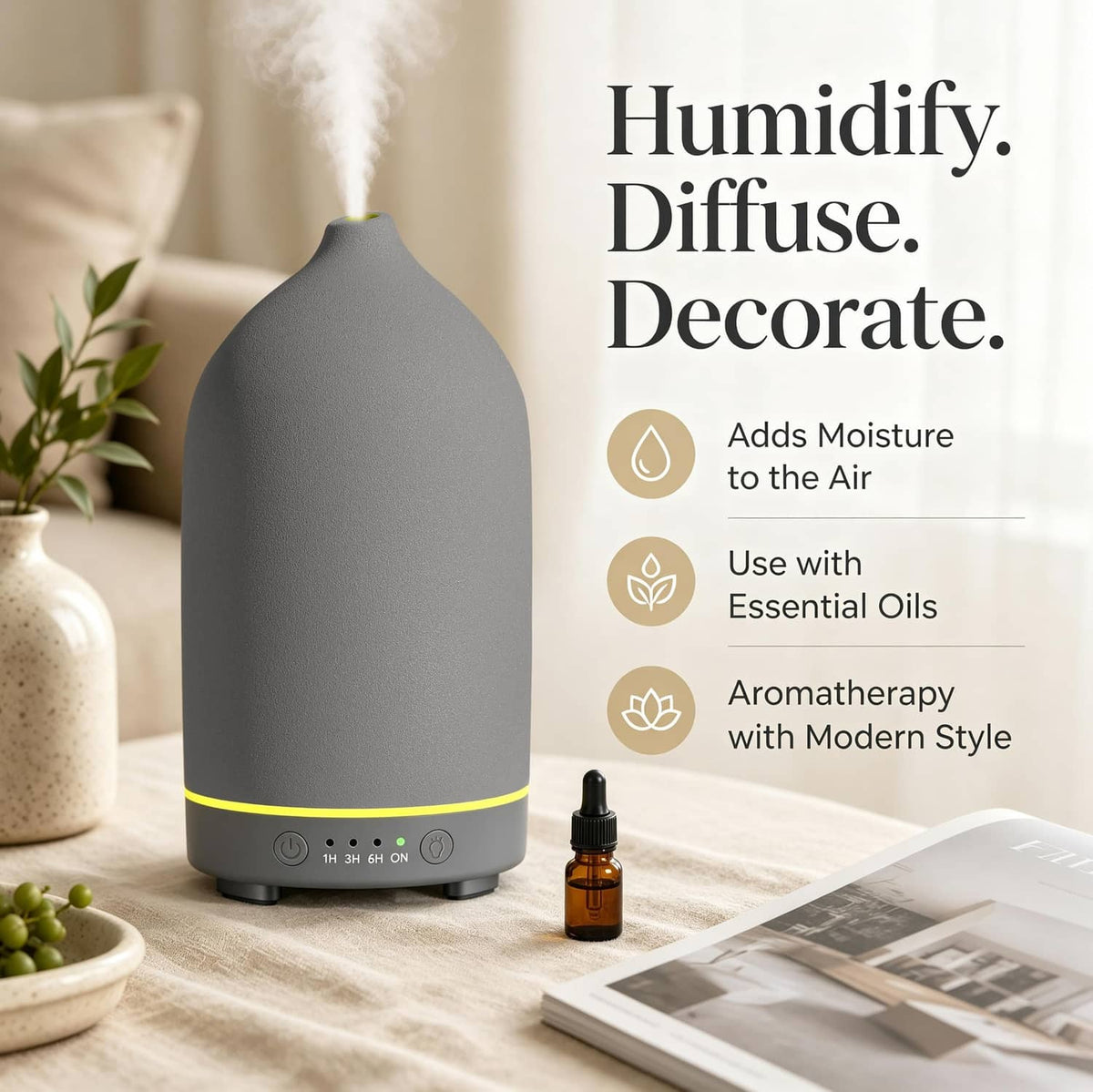 Grey ceramic essential oil diffuser on a table with small oil bottle
