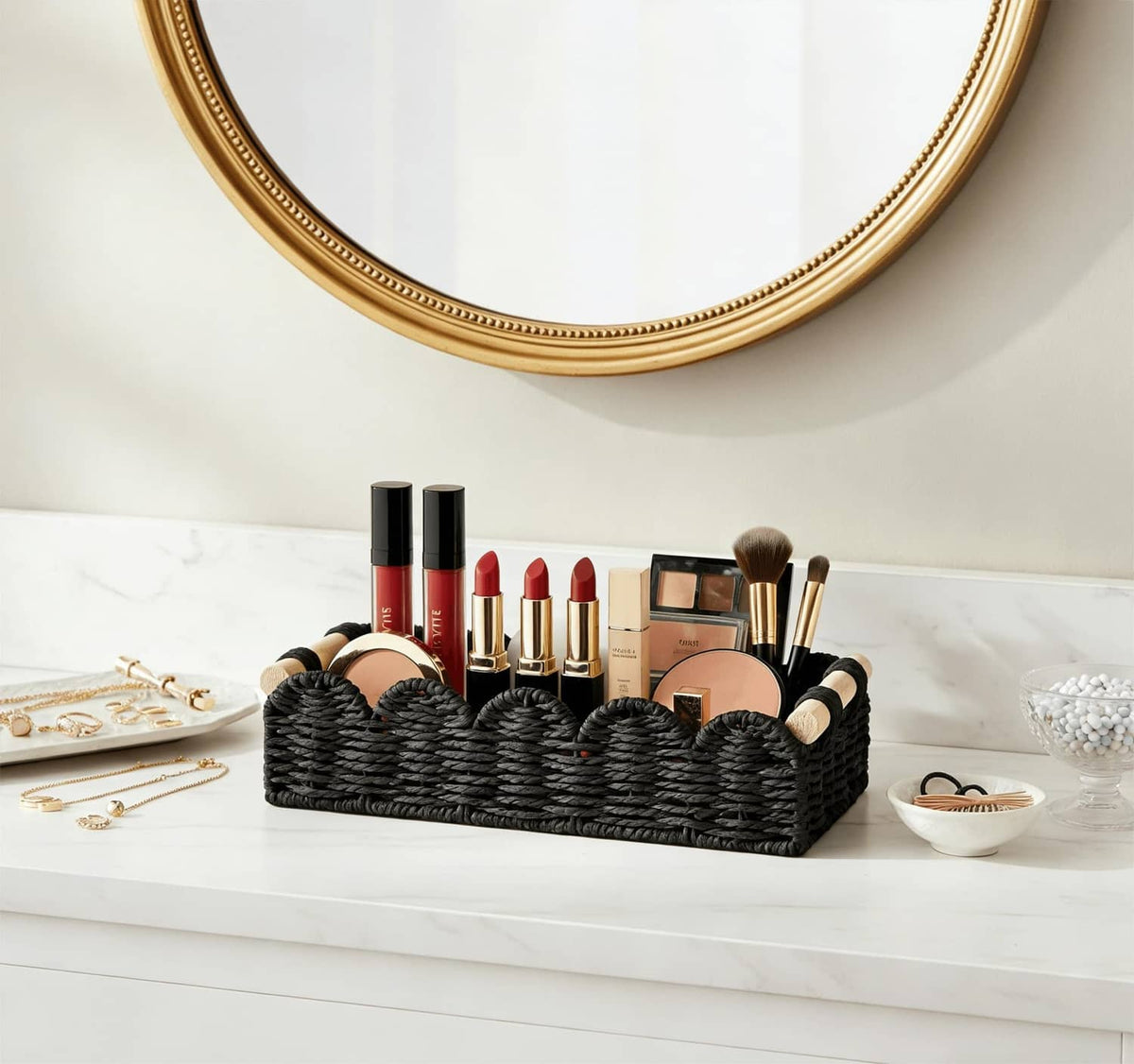Black woven storage basket with wood-capped handles holding cosmetics on a countertop