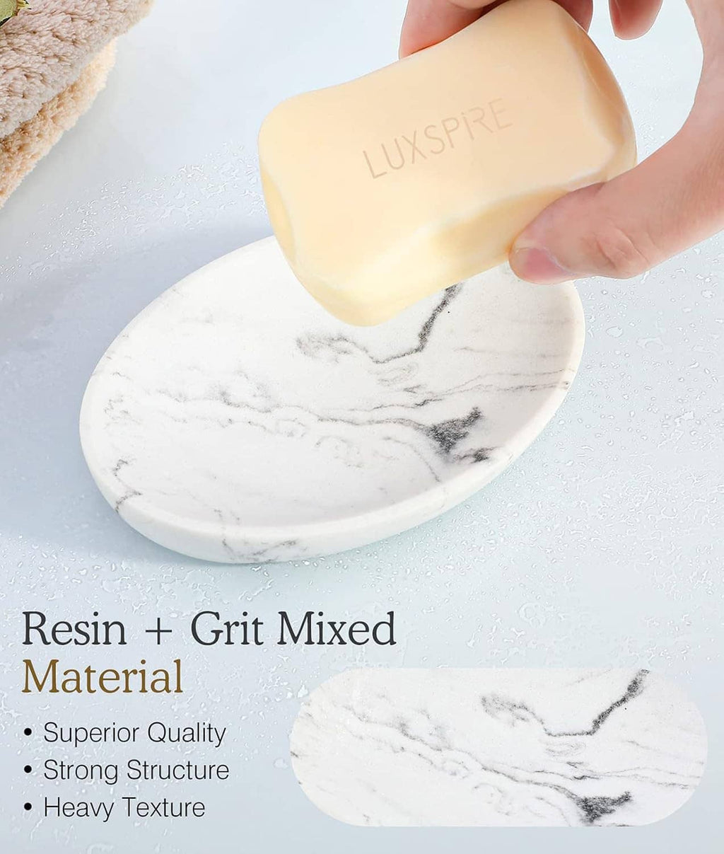 White marble oval soap tray with hand holding a bar of soap above it
