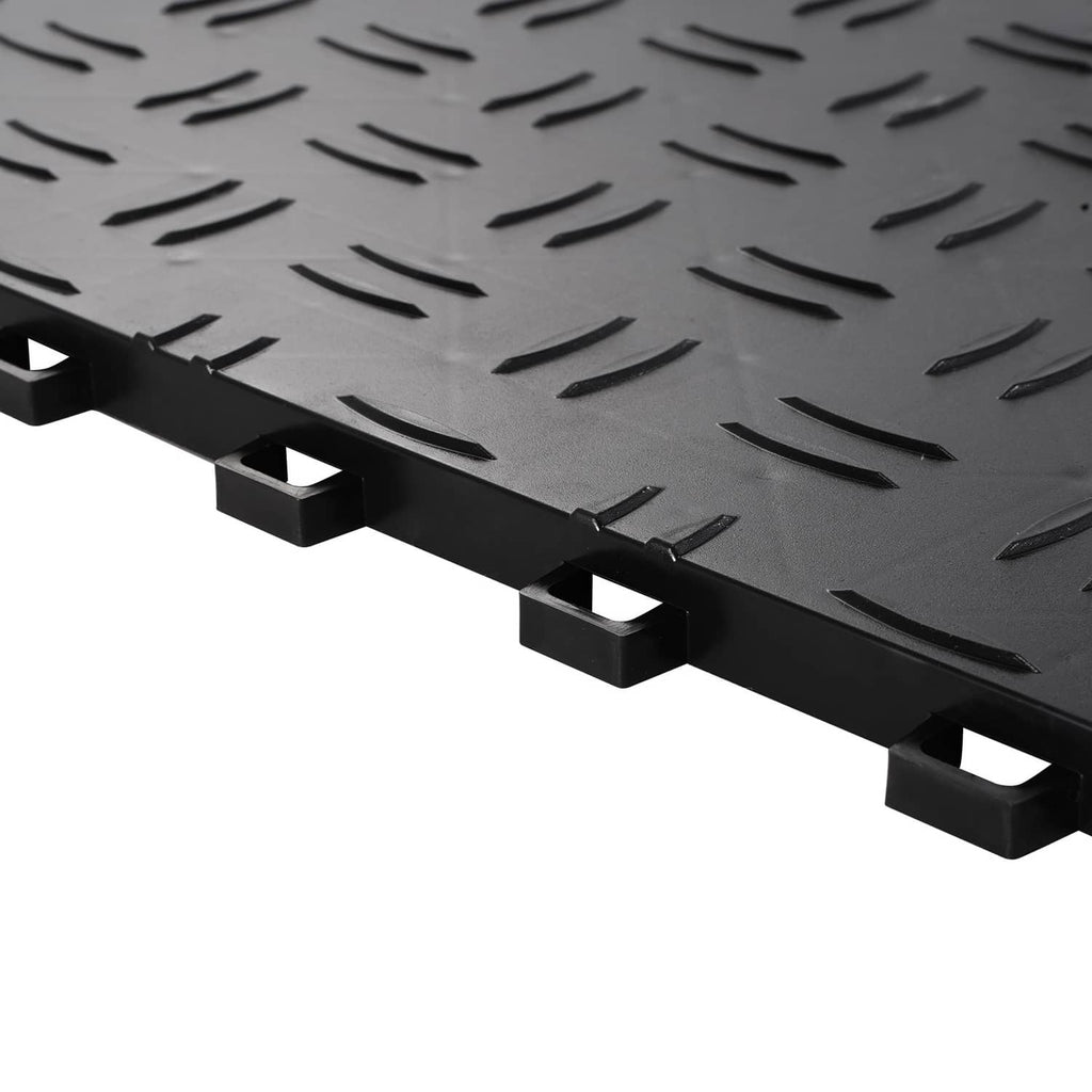 Close-up of black interlocking tile edge with raised studs and diamond tread texture