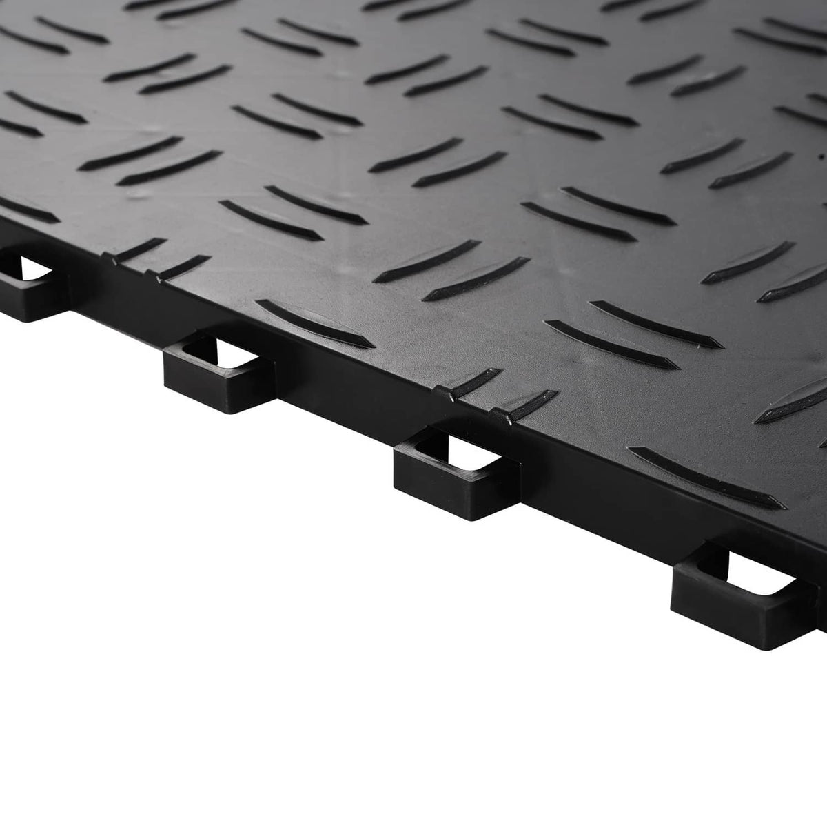 Close-up of black interlocking tile edge with raised studs and diamond tread texture