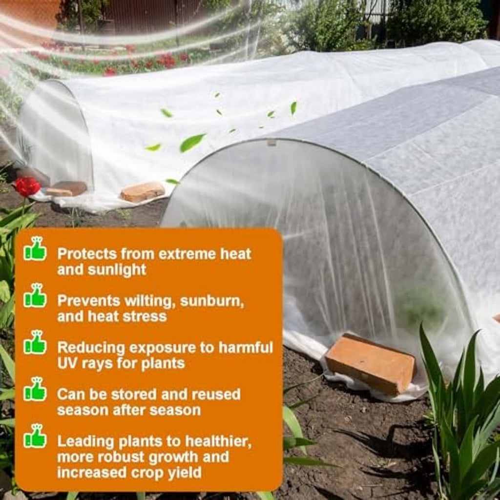 White sun protection cover on a hoop tunnel over garden plants and soil.