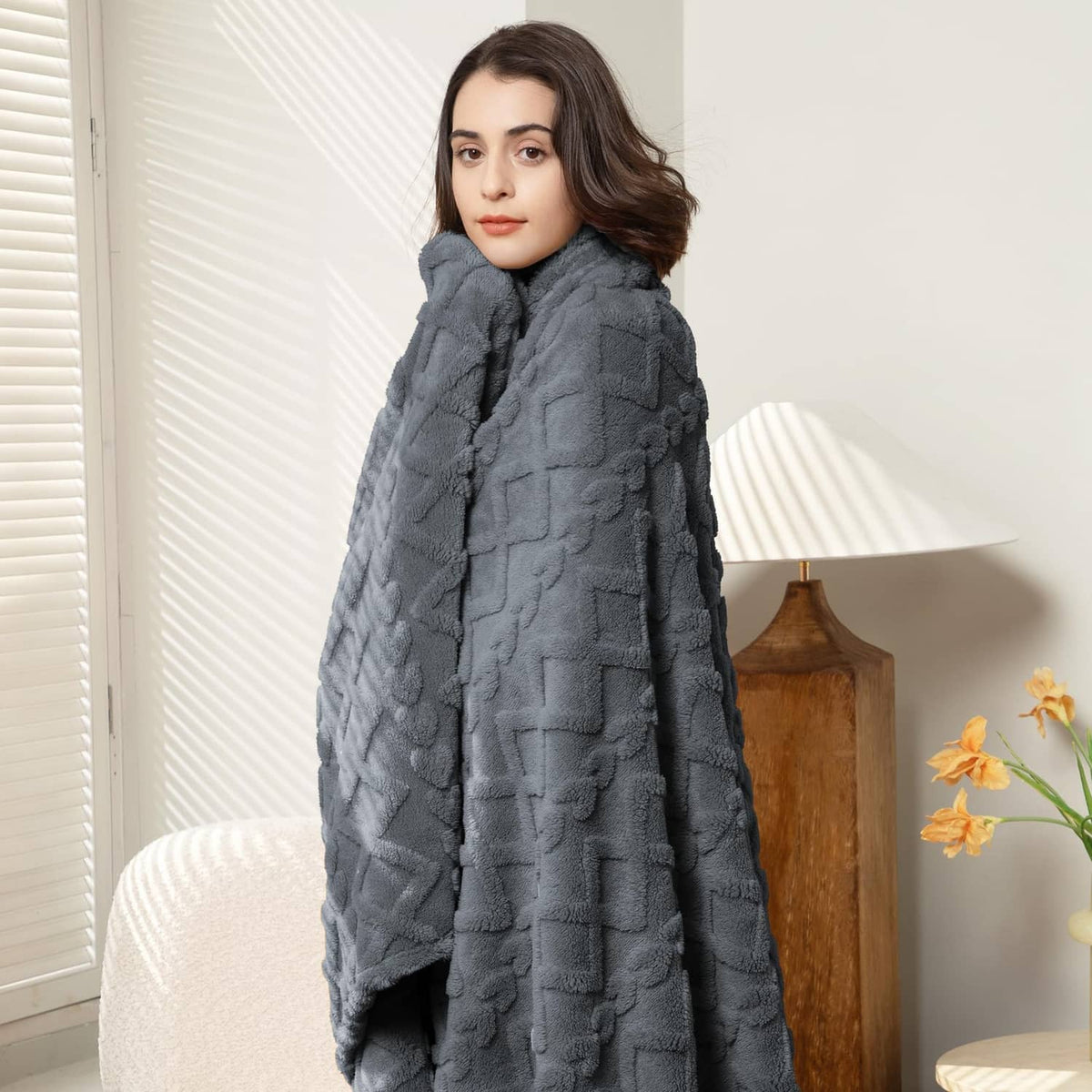 Gray textured plush blanket with raised pattern and ruched drape