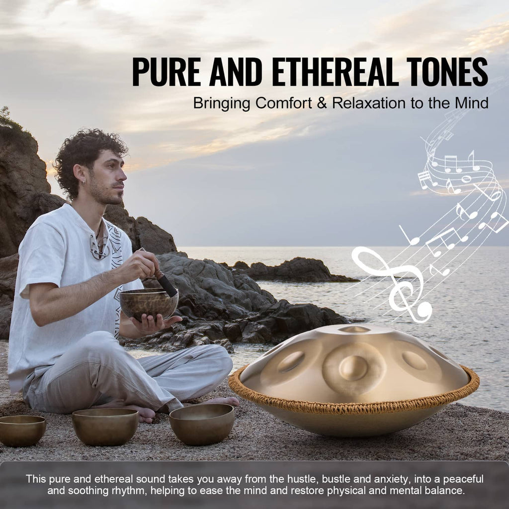 Handpan drum on the ground in front of a seated player, golden tone surface with dimples