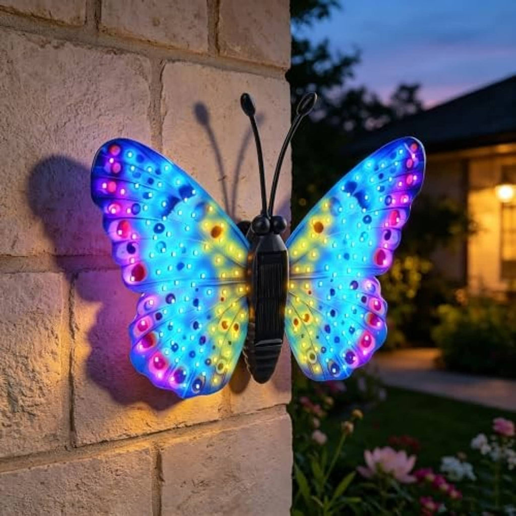 Solar LED butterfly wall decor with multicolor glowing wings on stone wall
