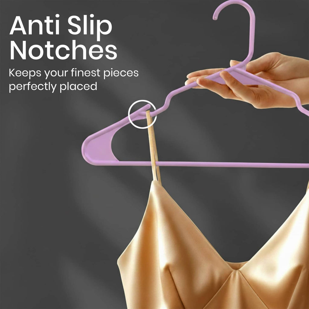 Pink plastic hanger with anti-slip notches, holding fabric by the curved arms