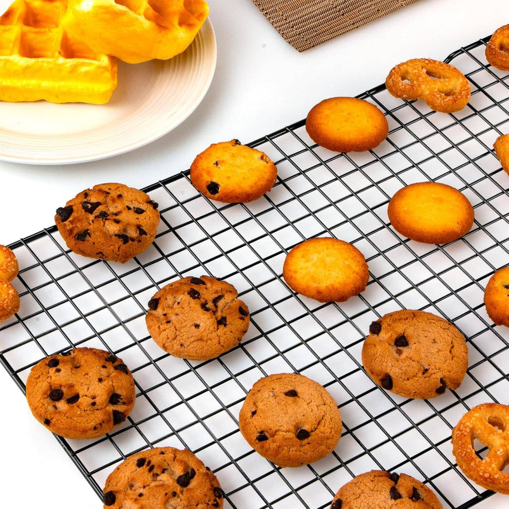 Black wire cooling rack with baked cookies cooling on the grid surface.