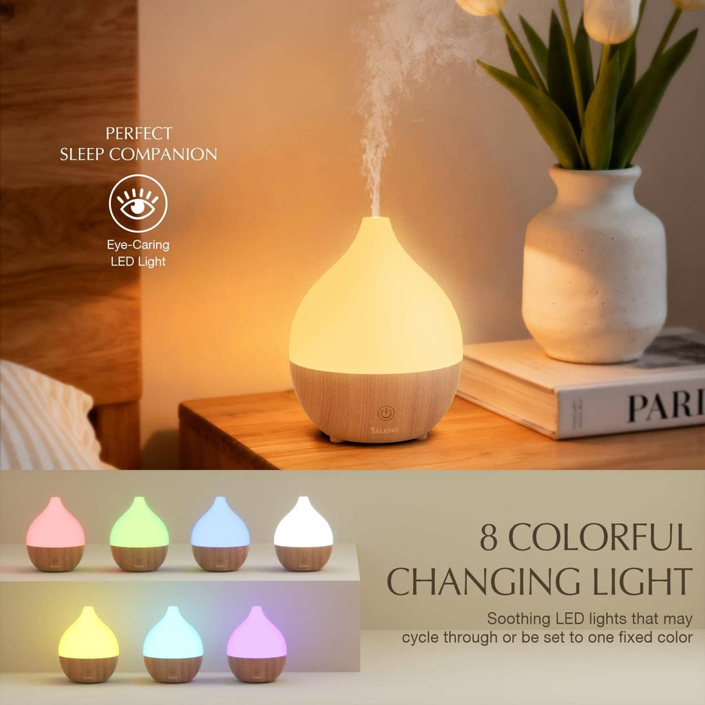 Essential oil diffuser with white cap, wood-grain base, warm LED glow