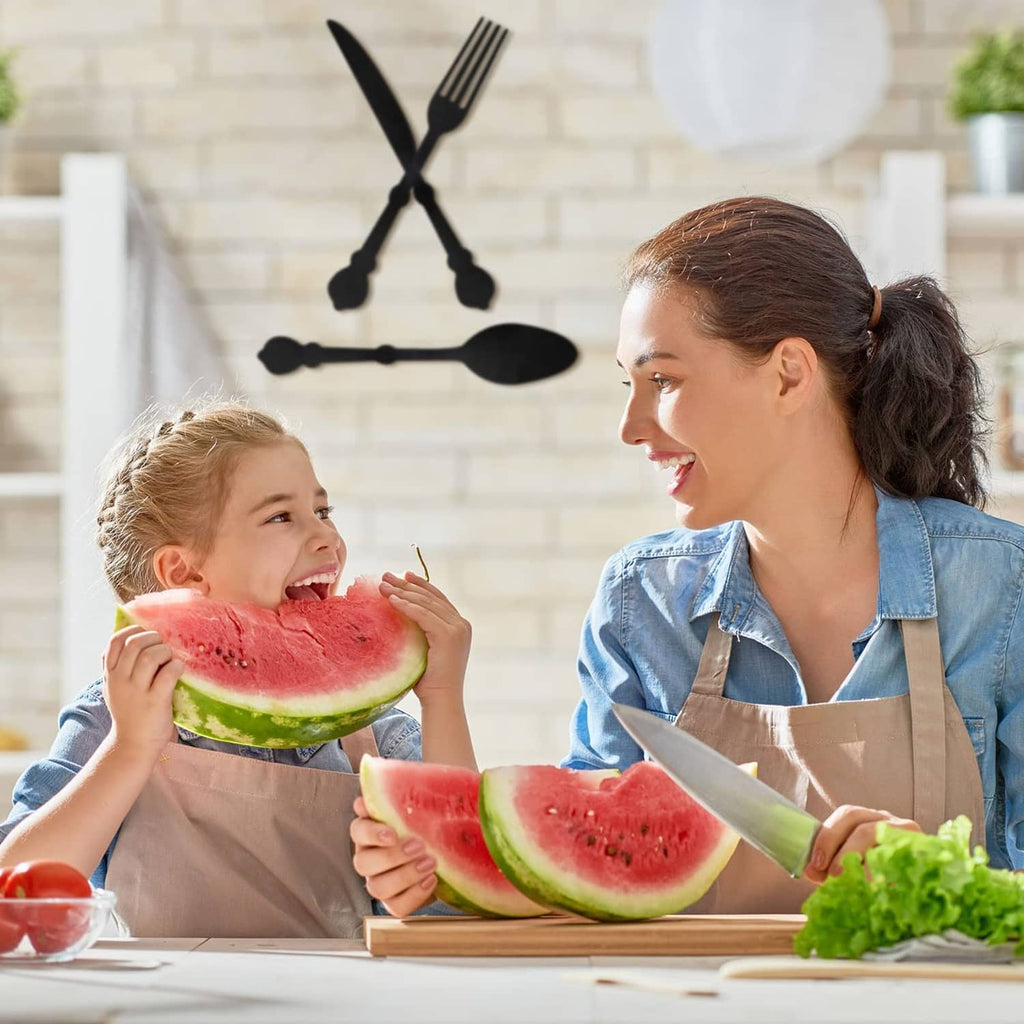 Three black wooden utensil wall decor pieces shaped like fork, spoon, and knife