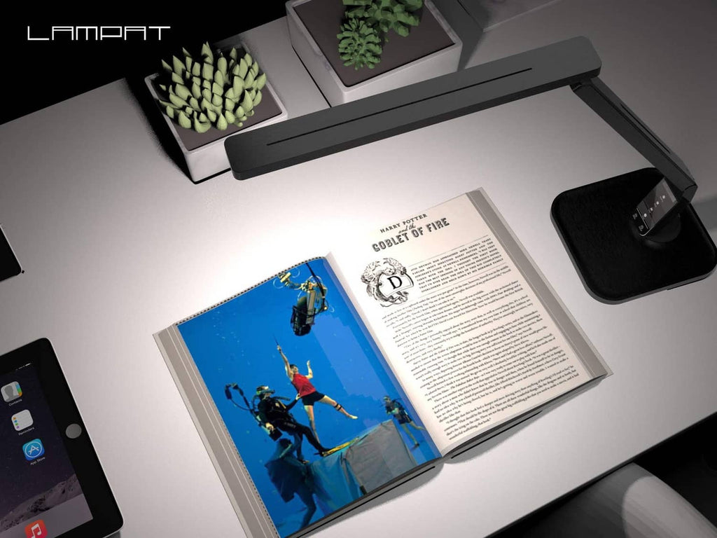 Black LED desk lamp over an open book, slim light bar raised