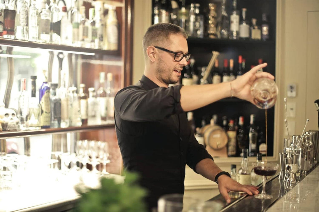 Bartender pouring from a bottle fitted with a metal pour spout