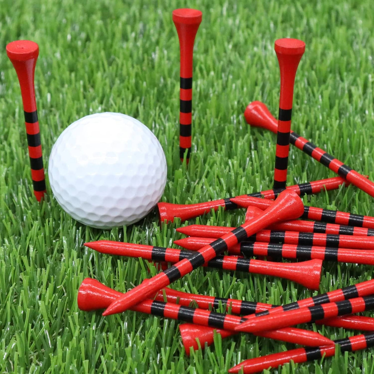 Red golf tees with black striped shafts and round heads, with a white golf ball