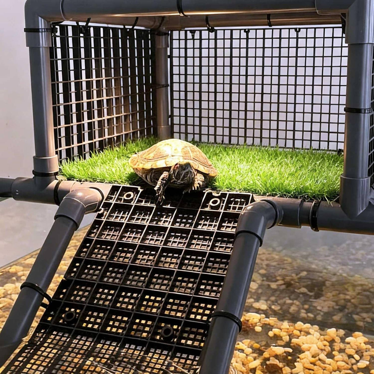 Turtle basking dock with green grass top, black ramp grate, and gray rails