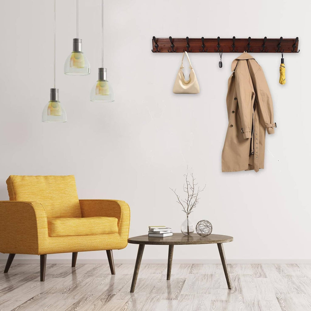 Wall-mounted coat rack with 10 black hooks on dark wood board in a living room