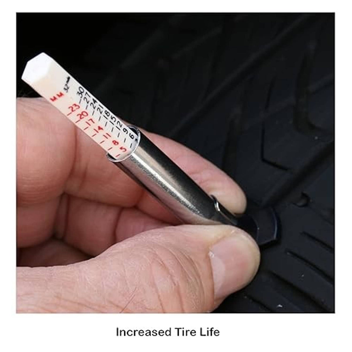 Hand holding a metal tire tread depth gauge tool with measurement markings