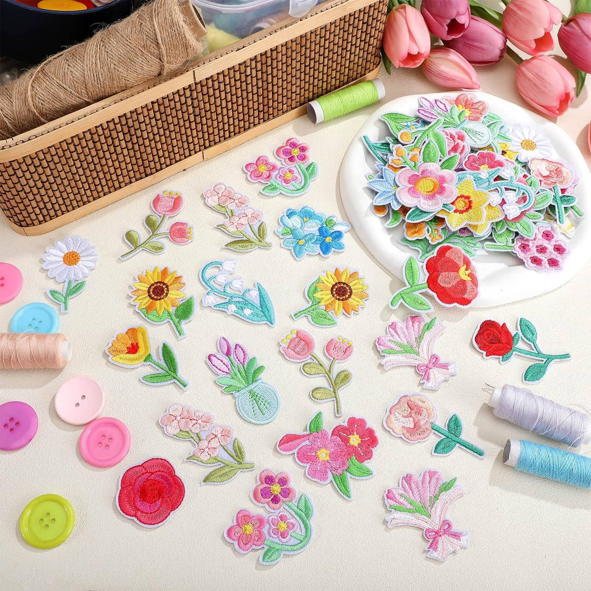 Pastel floral iron-on patches scattered with thread and pins for crafting