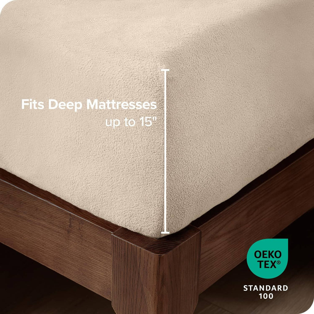 Cream fitted fleece bottom sheet corner covering deep mattress edge on a bed frame.