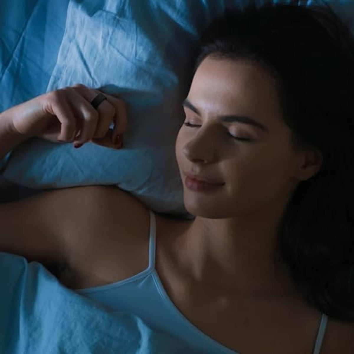 Black silicone smart ring protector near a person resting on a bed