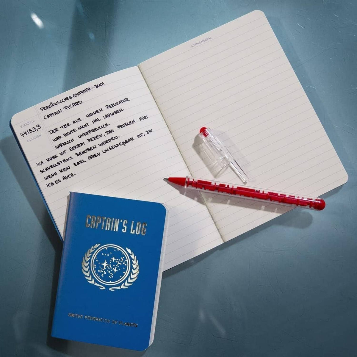 Open Captain's Log journal with lined pages and red-and-white pen