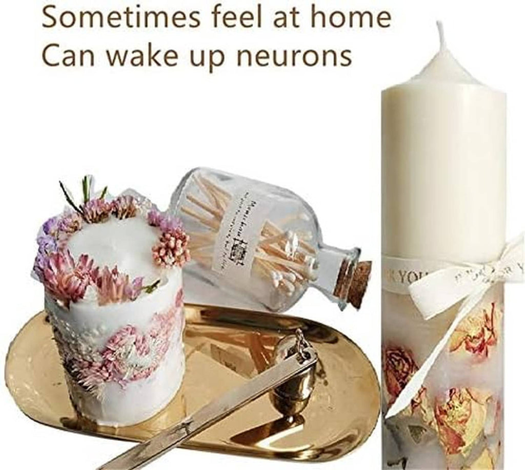 White cylinder candle molds holding pillar candles, one tied with ribbon and dried flowers.