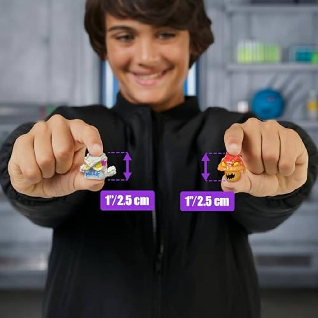 Boy holding two 1-inch micro-beast collectible figures with size markers