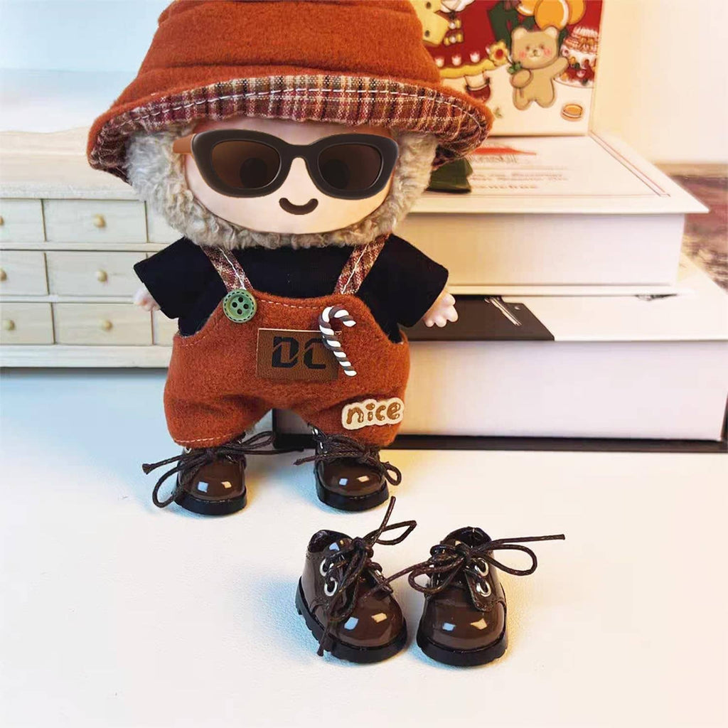 Mini doll shoes on display: brown lace-up boots and black lace-up shoes