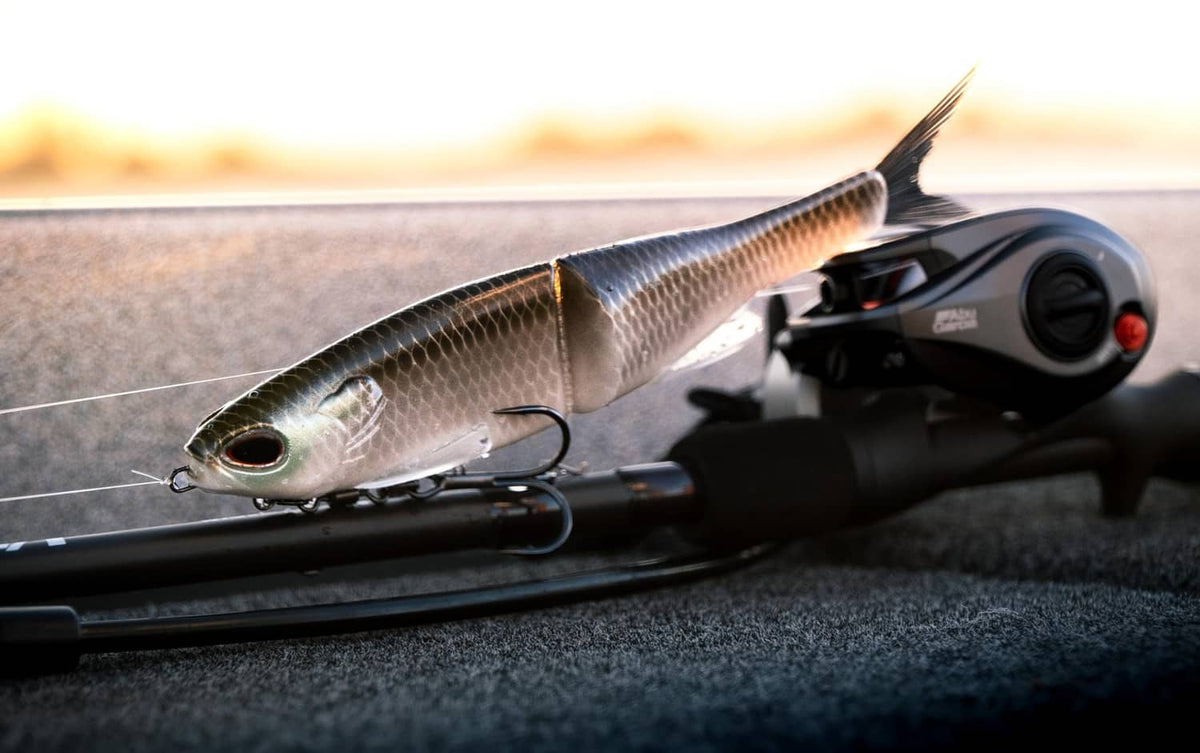 Green pumpkin soft plastic glide bait with treble hooks, on fishing line