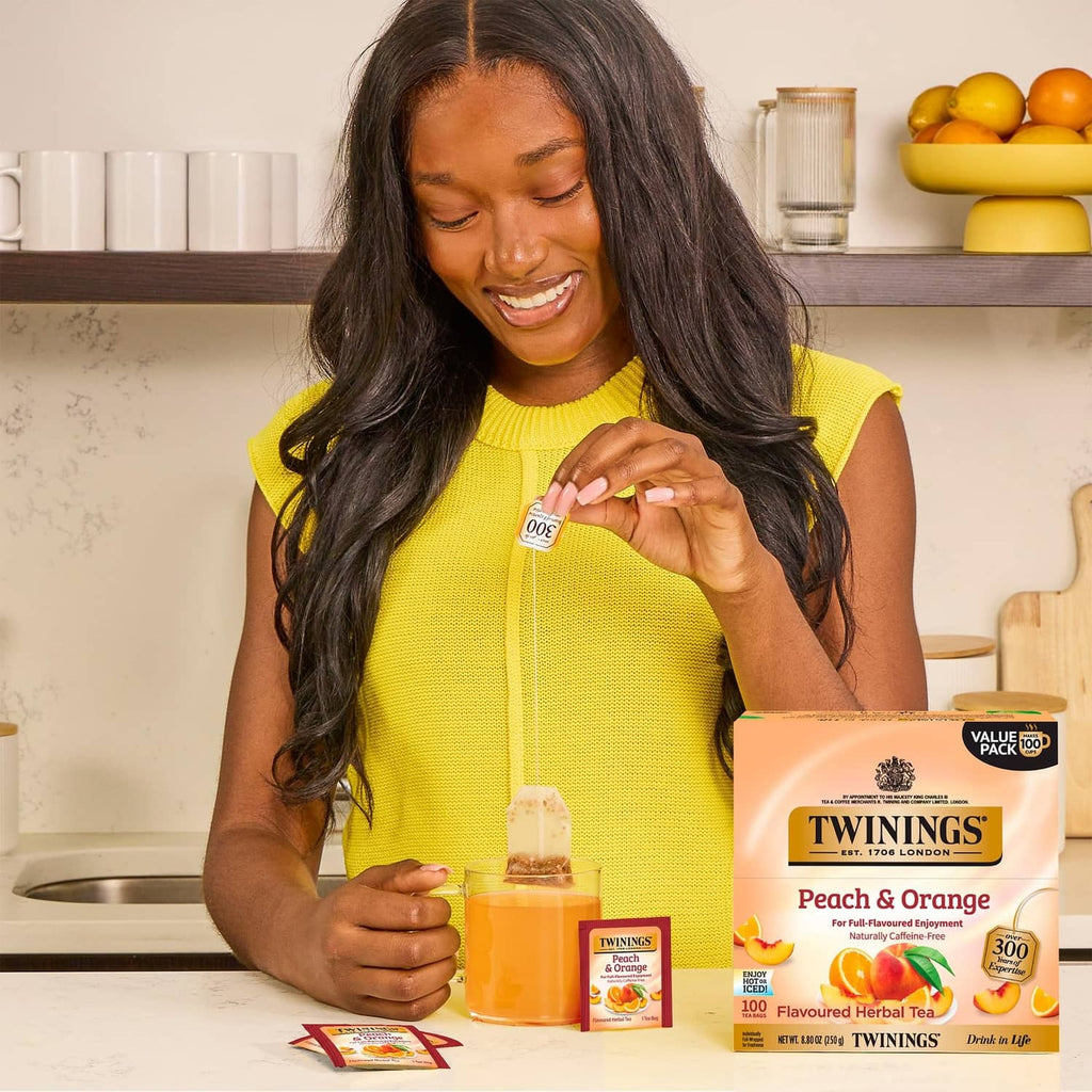 Twinings Peach & Orange herbal tea pack and tea bag, being opened
