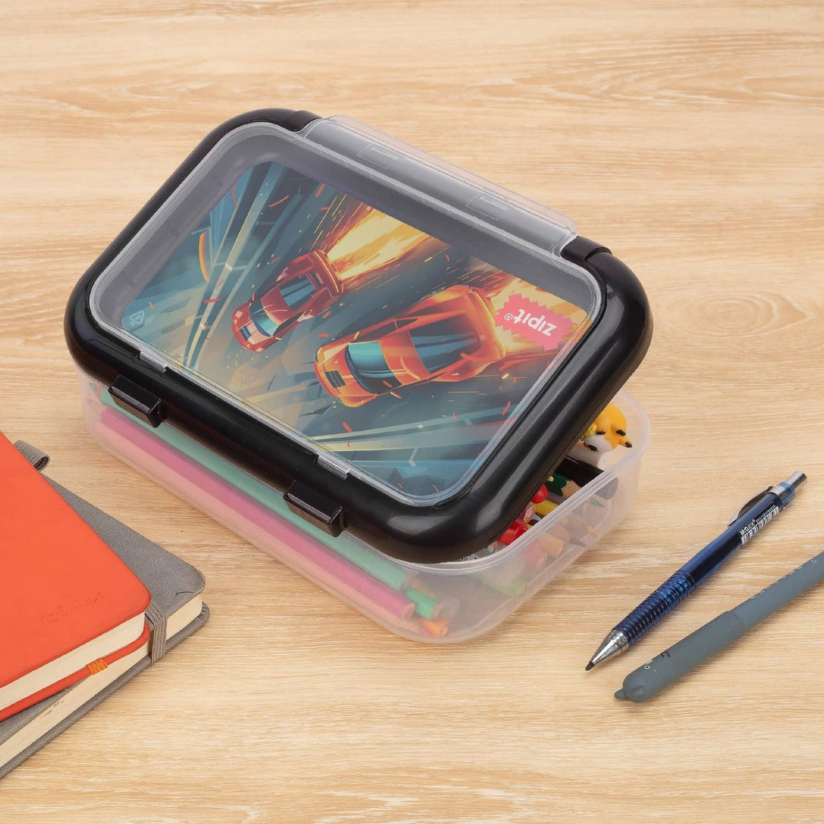 Rainbow-edged clear pencil box with black lid and car print, two compartments.