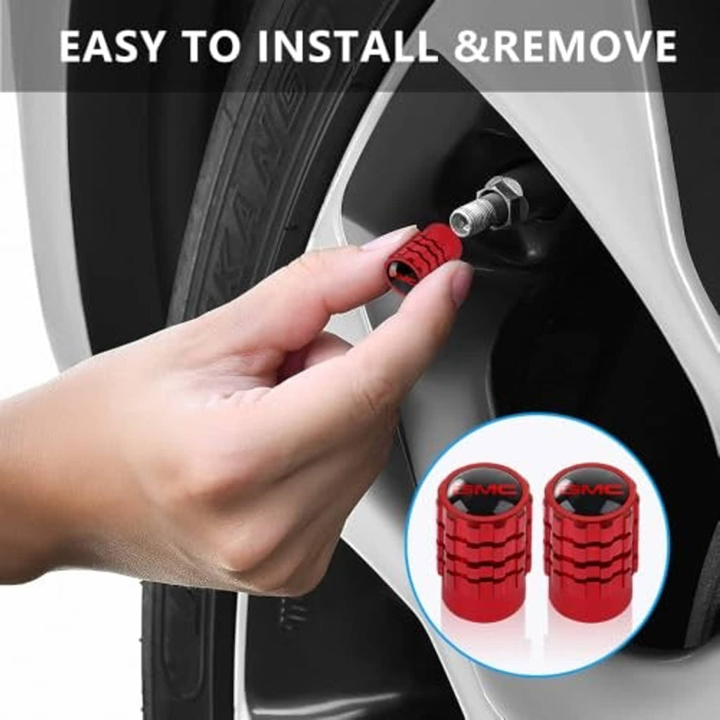 Red tire valve stem cap installed by hand on a wheel valve, ridged GMC logo cover