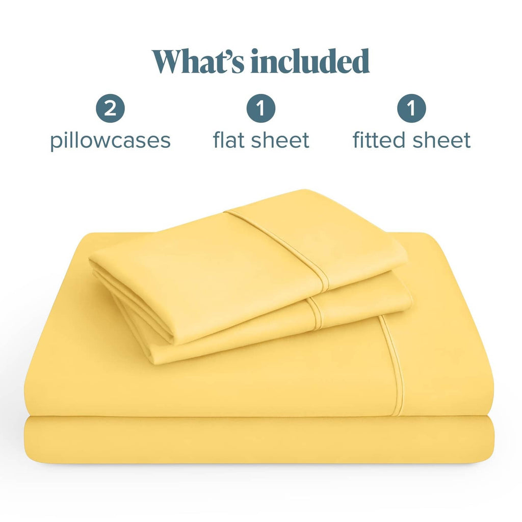 Lemon-yellow microfiber sheet set folded: 2 pillowcases, flat sheet, and fitted sheet.