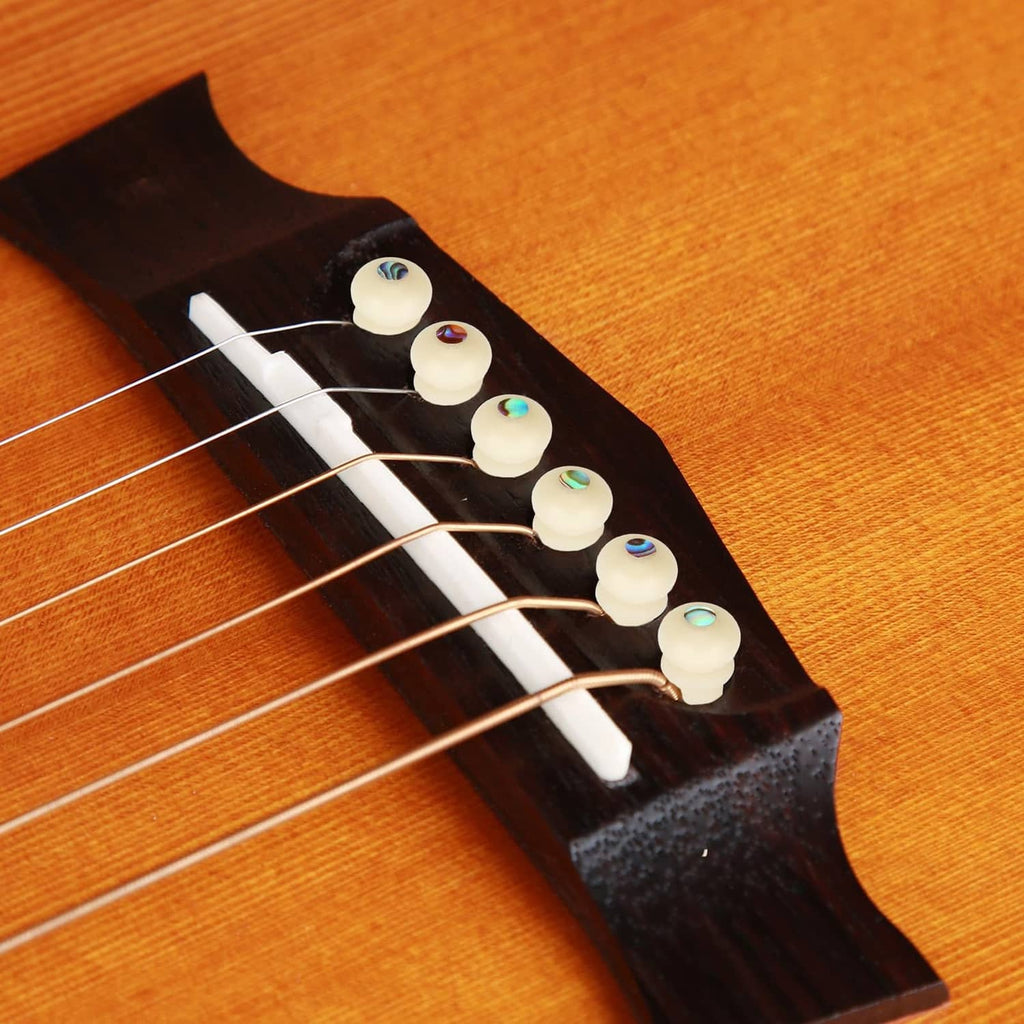 6 natural bone-look guitar bridge pins installed on a wooden bridge, iridescent inlays