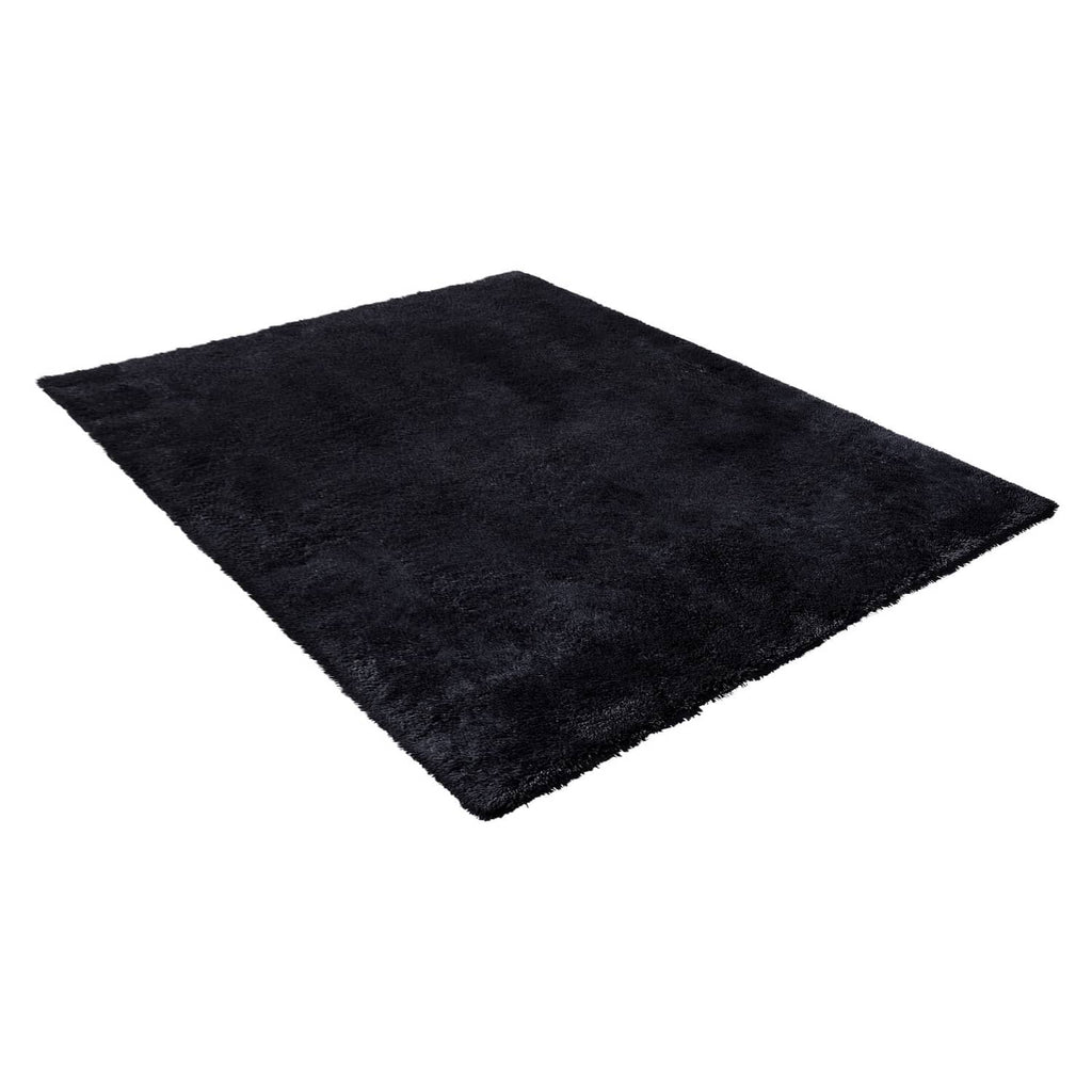 Black plush rectangular area rug with thick shag texture and rounded corners