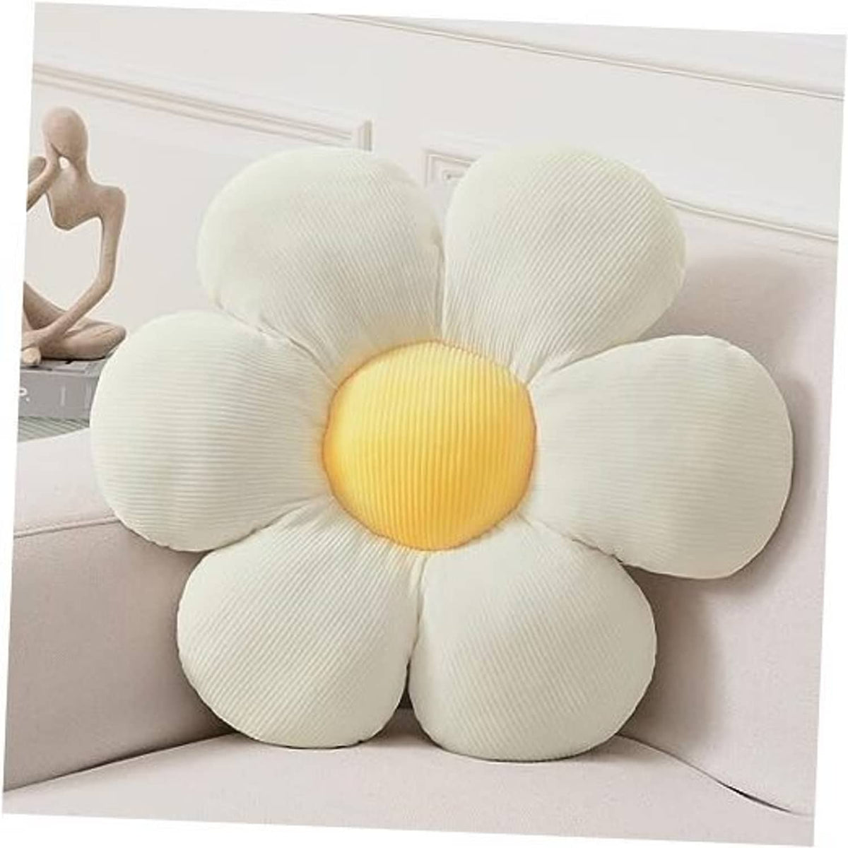 White flower shaped throw pillow with yellow center, on a light sofa