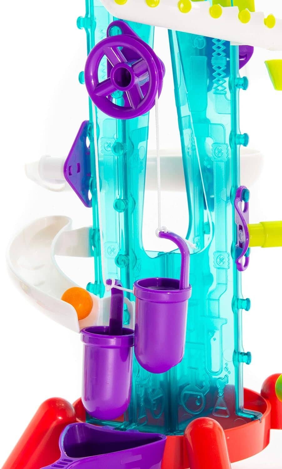 Close-up of clear teal gumball machine with purple cups and white circular track.