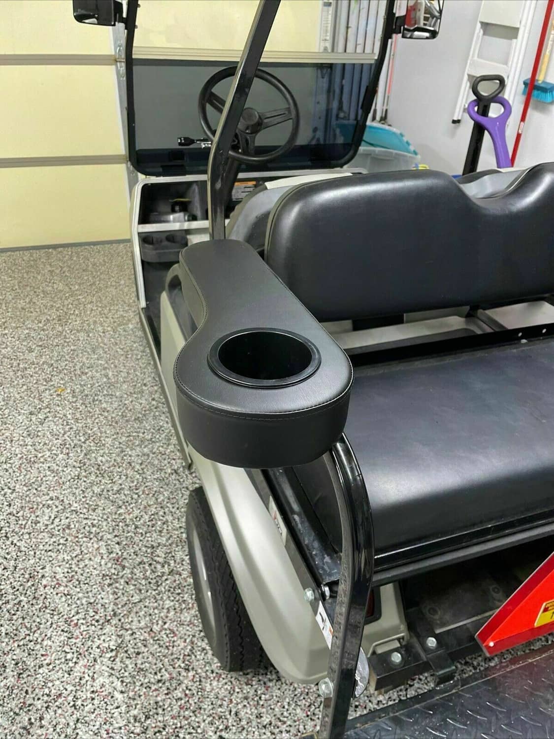 Golf cart rear arm rest with round cup holder installed on seat, black