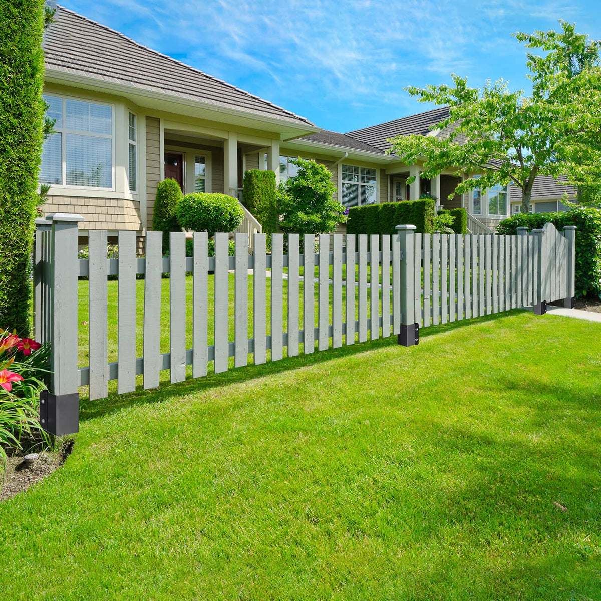 Black fence post ground anchors securing a white picket fence outdoors
