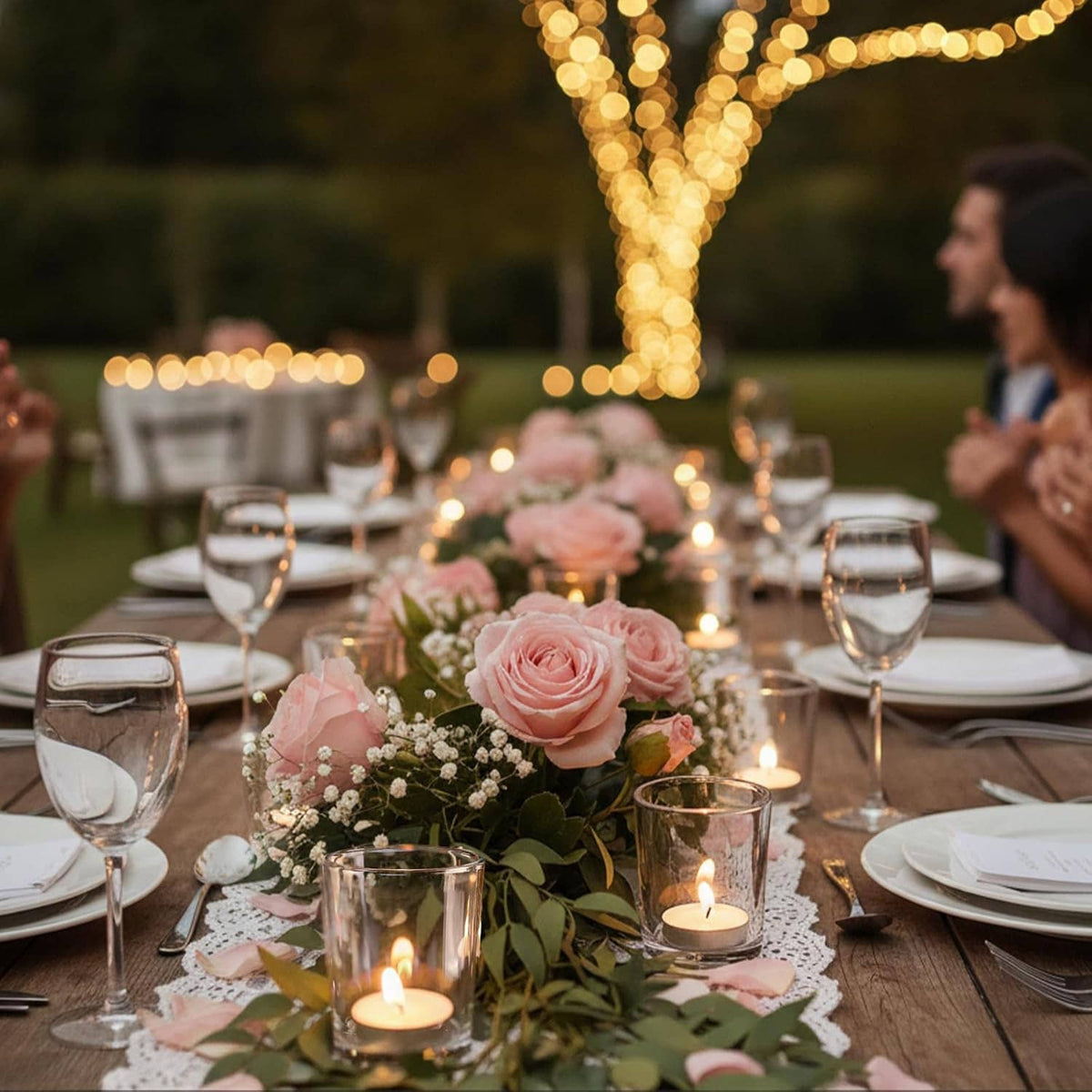 Clear glass votive candle holders with lit tea lights on a table centerpiece