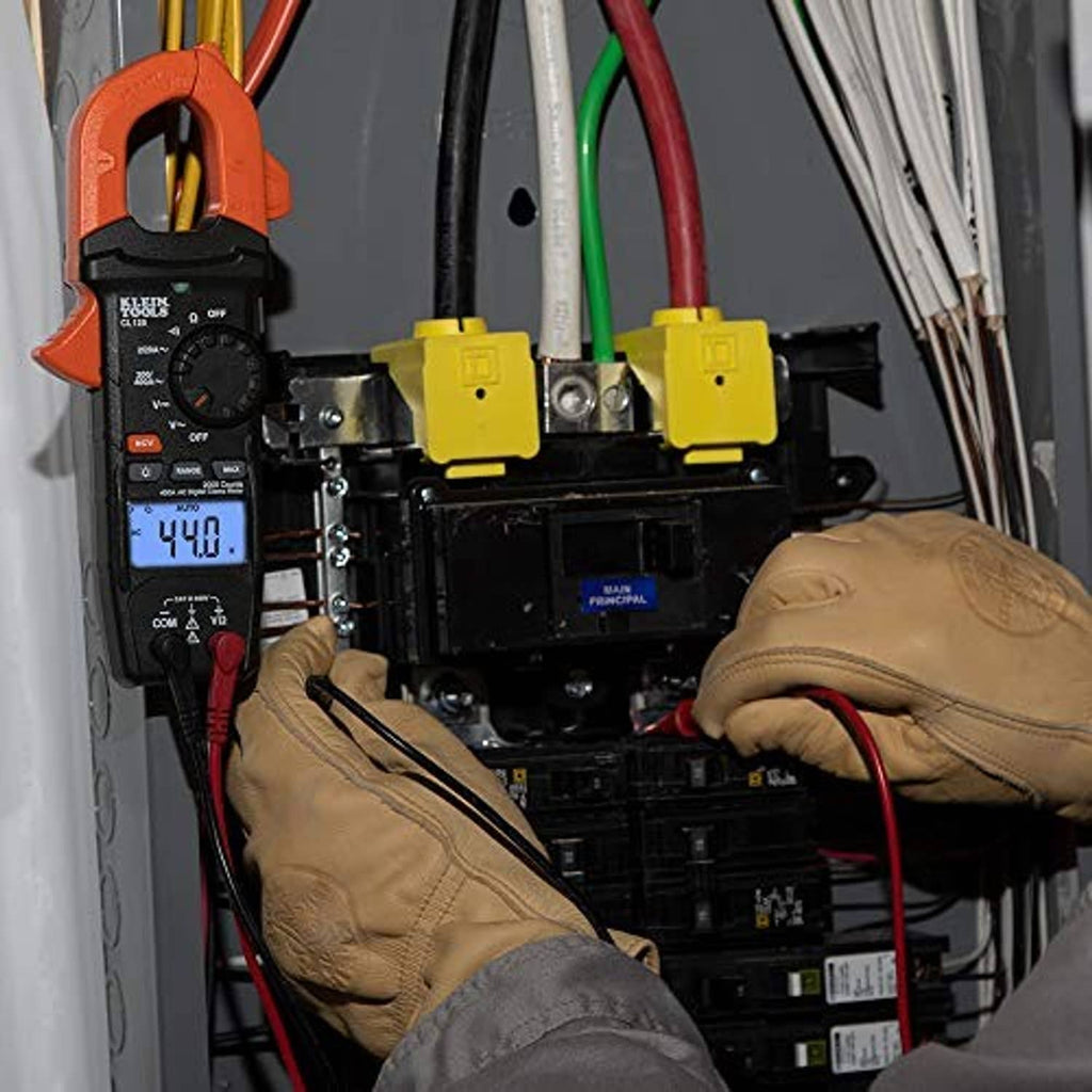 Digital clamp meter clamped near busbars with 44.0 reading on the display.