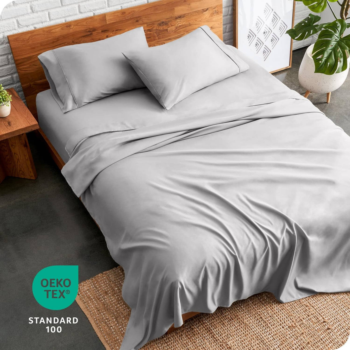 Light grey king sheet set on bed with two pillowcases and draped sheet