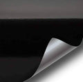 Black high-gloss paint-like vinyl wrap film sheet, realistic microfinish with curled edge