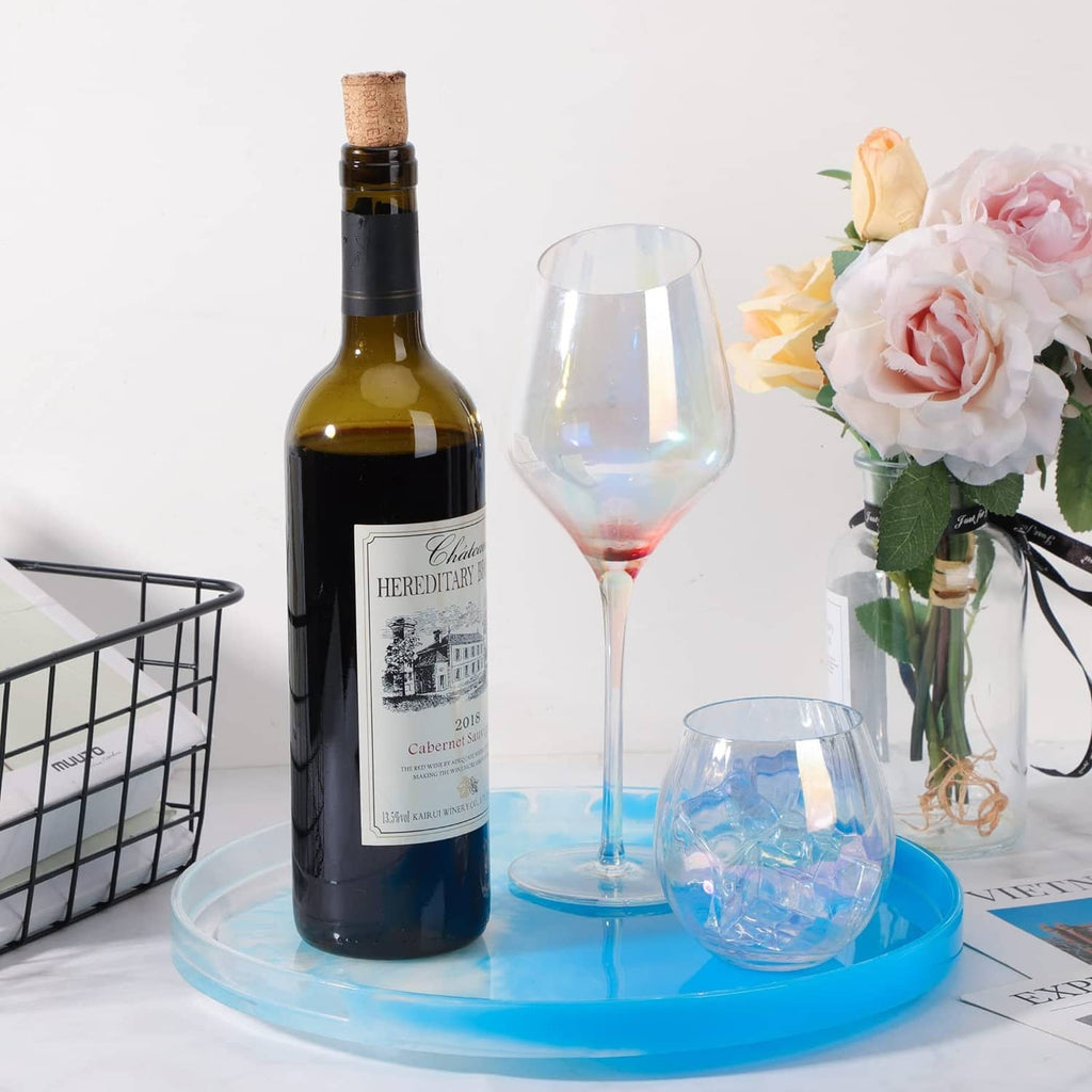 Large round resin tray mold in blue, holding decorative bottles and wine glass